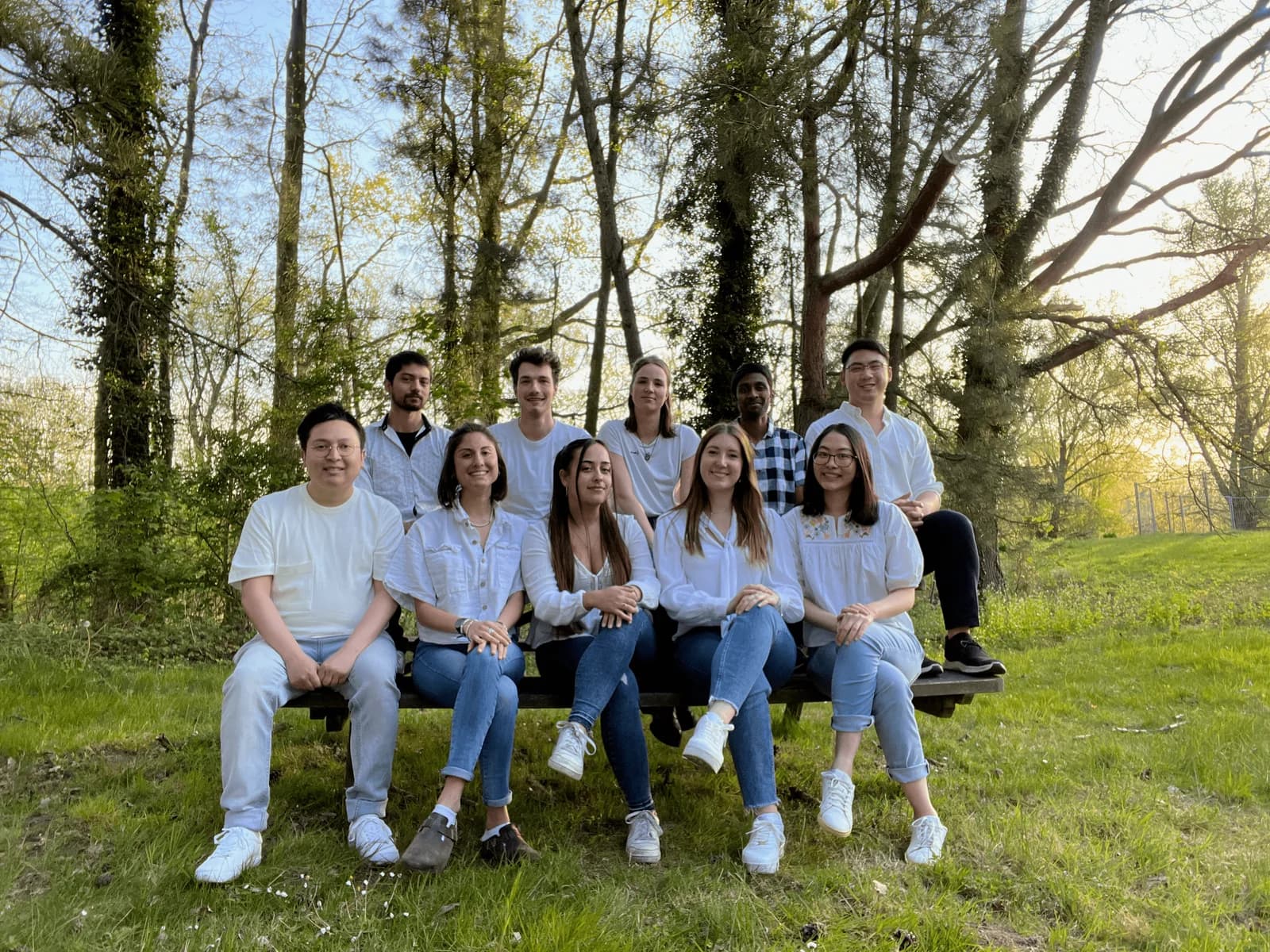 iGEM Leuven 2022 team photo, ten members on a bench in a wooded park